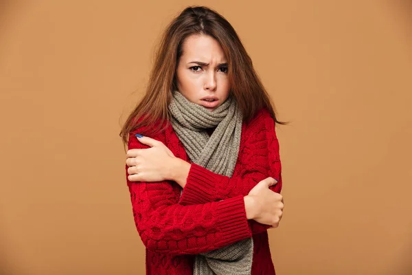 Porträt einer traurig frierenden brünetten Frau in rotem Strickpulli — Stockfoto