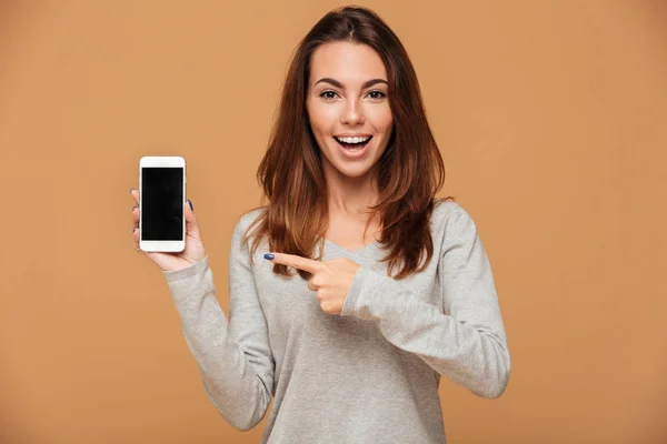 Close-up portrait of young smiling brunette woman pointing with — Stock Photo, Image