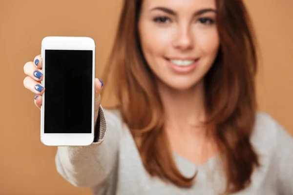 Recortado foto de alegre morena mujer mostrando pantalla en blanco mo —  Fotos de Stock