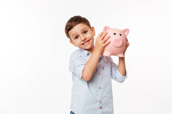 Retrato de uma criança engraçada alegre segurando banco porquinho — Fotografia de Stock