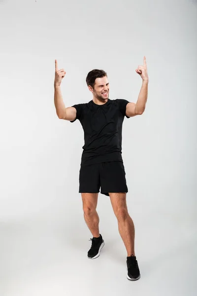 Retrato completo de un joven deportista satisfecho celebrando — Foto de Stock