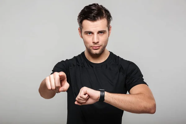 Portrét jistý mladého sportovce, ukazující jeho Náramkové hodinky — Stock fotografie