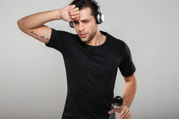 Portrait of a tired exhausted sportsman listening to music