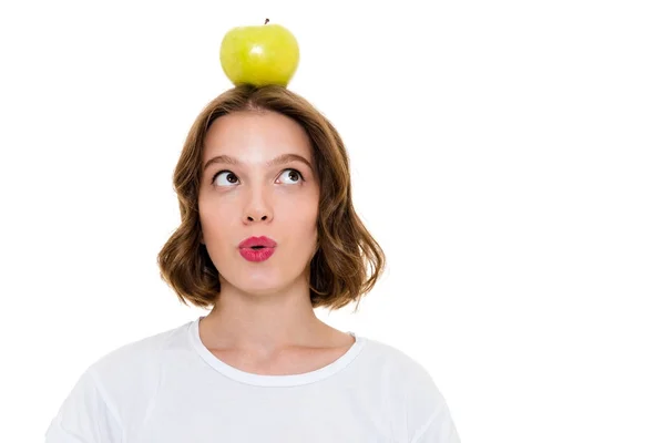 Thinking pretty caucasian woman holding apple on head — Stock Photo, Image