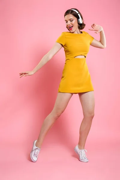Vzrušený šťastná mladá dáma ve žlutých šatech tančí — Stock fotografie