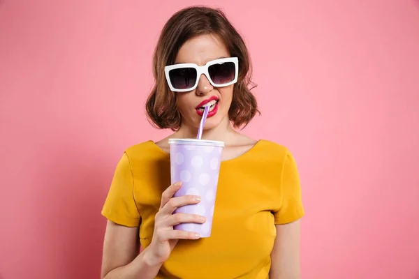Portrét dívky v sluneční brýle drží šálek s nápojem — Stock fotografie