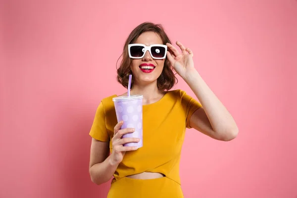 Portrait d'une fille gaie dans des lunettes de soleil tenant tasse — Photo