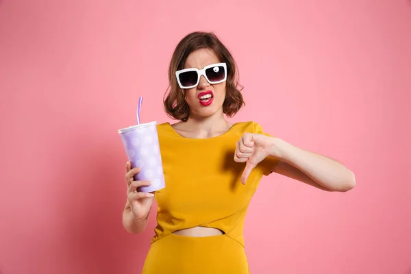 Retrato de uma menina decepcionada em óculos de sol segurando copo — Fotografia de Stock