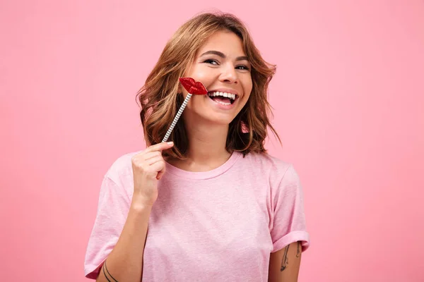 Ευτυχισμένη γυναίκα απομονωμένη σε ροζ φόντο ποζάρει με ψεύτικα χείλη — Φωτογραφία Αρχείου