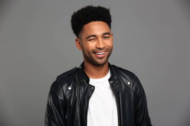 Siyah deri ceketli Afrikalı adamı gülümseyen genç bir göz kırpmak,