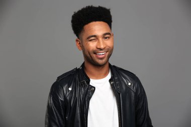 Siyah deri ceketli Afrikalı adamı gülümseyen genç bir göz kırpmak,