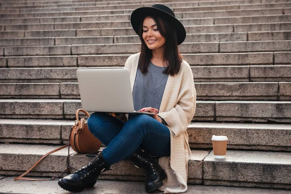 Retrato de una mujer bonita sonriente usando computadora portátil — Foto de Stock