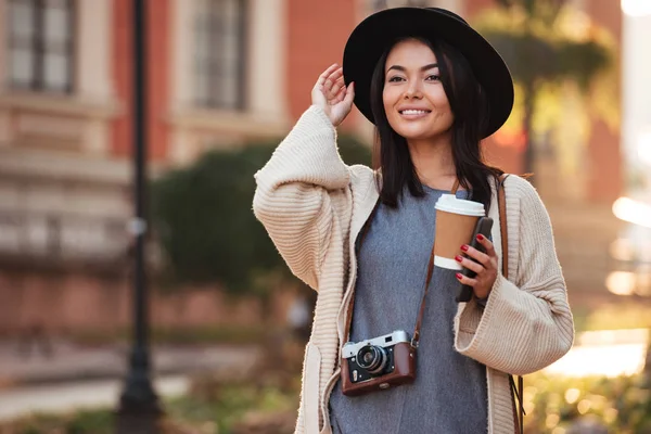 Jovem encantador asiático mulher no preto chapéu segurando takeaway café — Fotografia de Stock