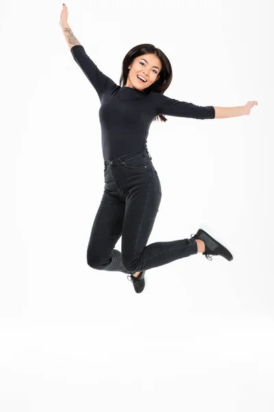 Lächelnde junge asiatische Frau springt — Stockfoto