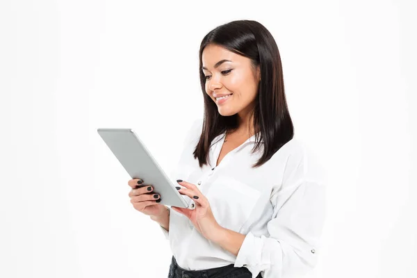 Cheerful young asian lady chatting by tablet computer — Stock Photo, Image