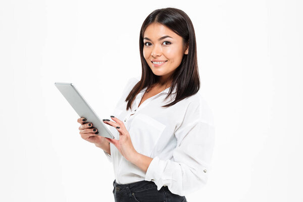 Happy young asian lady chatting by tablet computer