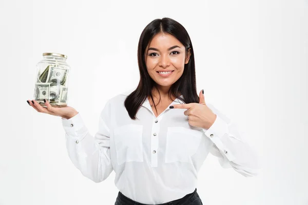 Happy asian lady holding jar with money showing thumbs up. — Stock Photo, Image