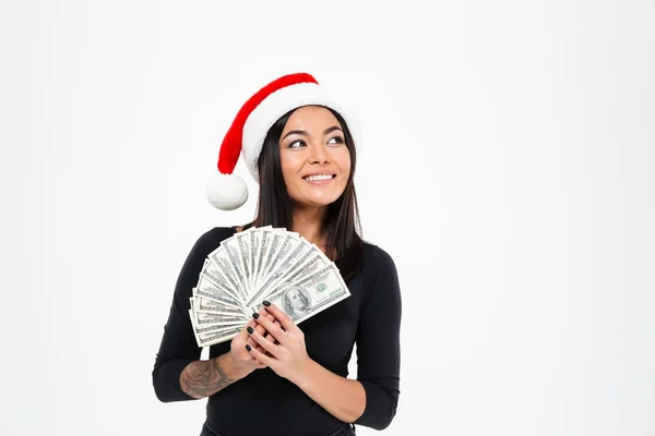 お金を入れるクリスマス帽子をかぶっている幸せな若いアジア女性. — ストック写真
