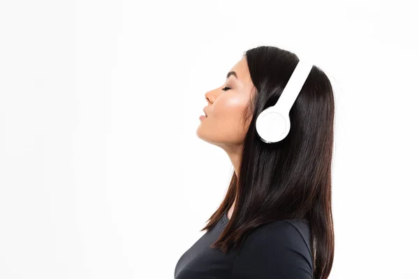 Unga asiatiska damen lyssnar musik med hörlurar — Stockfoto
