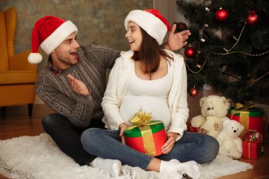 Neşeli genç hamile kadın kocasıyla kutluyor