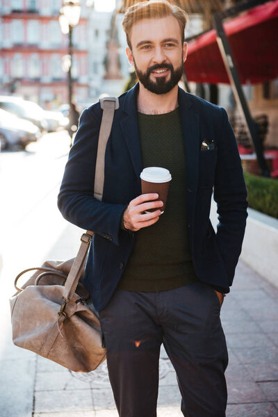 Portrait of a smiling bearded man drinking coffee