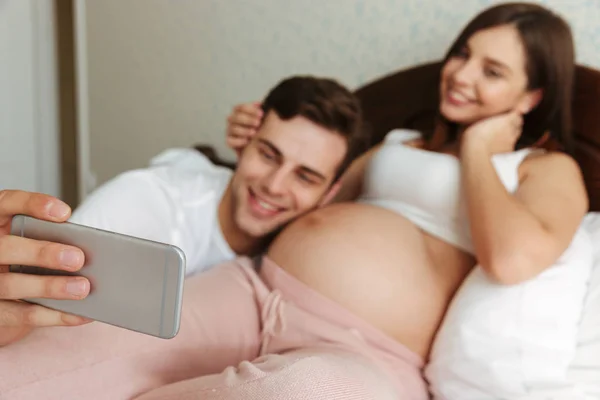 Молодая беременная пара делает селфи — стоковое фото