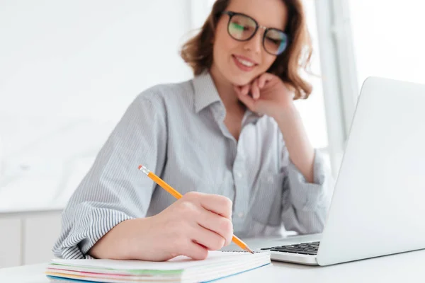 Vacker elegant kvinna i fritidskläder skriva anteckningar samtidigt sitti — Stockfoto