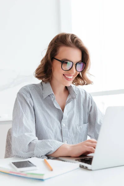 Primer plano retrato de chica alegre bunette en gafas usando lapt — Foto de Stock