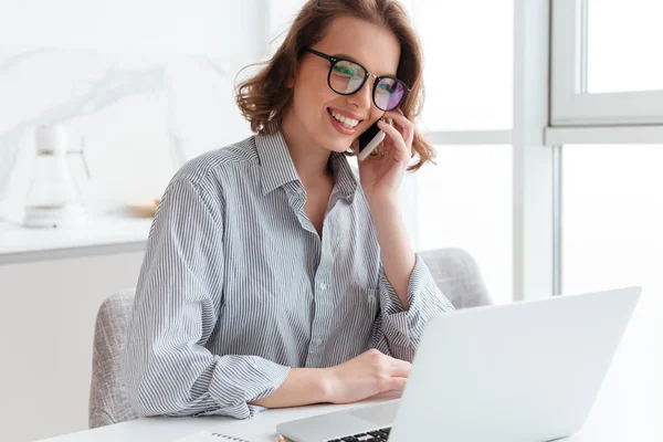 Encantadora chica morena en gafas y ropa casual hablando en la mafia — Foto de Stock