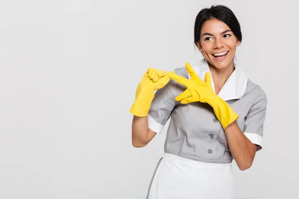 Mulher bonita morena em uniforme cinza tirando seu prot amarelo — Fotografia de Stock