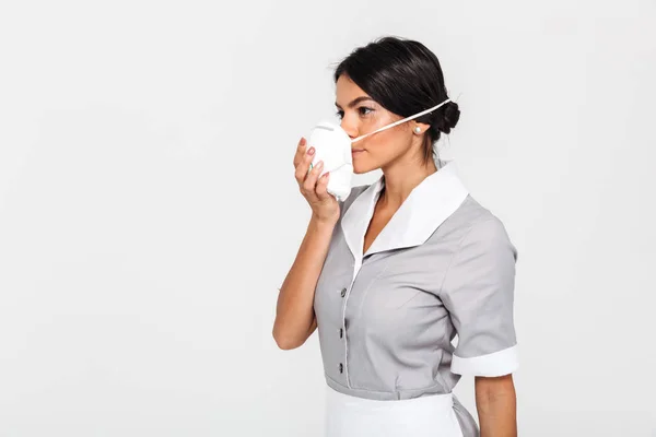 Foto da vicino di una giovane donna bruna in uniforme che si mette pro — Foto Stock