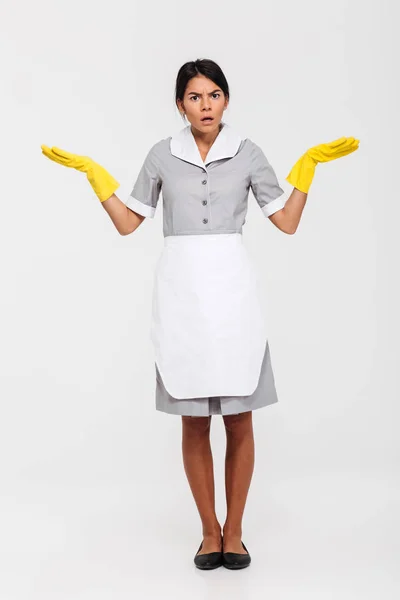 Foto de comprimento total de empregada surpreendida em uniforme cinza e amarelo — Fotografia de Stock
