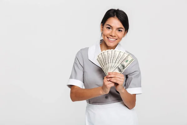 Portrait of young attractive female maid holding bunch of money — Stock Photo, Image