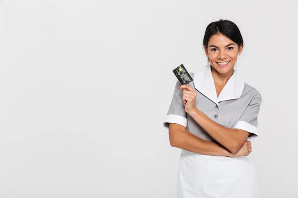 Portrait of smiling pretty woman in uniform holding credit card — Stock Photo, Image