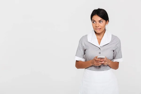 Portret van mooie jonge brunette vrouw in uniform bijt een lip — Stockfoto