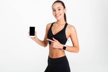 Gülümseyen Asya fitness kadın işaret eden bir parmağa portresi