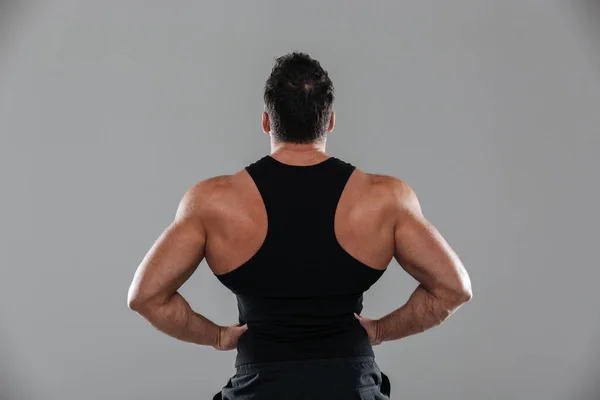 立っている健康な強い男性のボディービルダーの背面図 — ストック写真