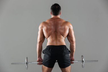 Kaslı bir üstsüz erkek vücut geliştirmeci portresi arkadan görünüm