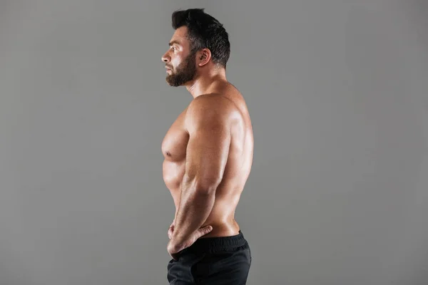 Side view portrait of a concentrated strong shirtless male bodybuilder — Stock Photo, Image