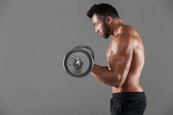 Side view of a serious strong shirtless male bodybuilder — Stock Photo, Image