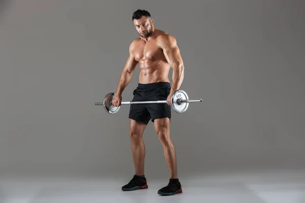 Ganzkörperporträt eines muskulösen, ernsthaften, hemdlosen männlichen Bodybuilders — Stockfoto