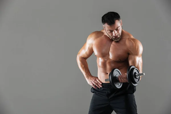 Portret van een ernstige sterke mannelijke shirtless bodybuilder opheffen — Stockfoto