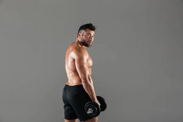 Vista laterale ritratto di un serio forte bodybuilder maschio senza maglietta — Foto Stock