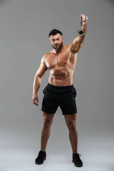 Volledige lengte portret van een tevreden sterke shirtless mannelijke bodybuilder — Stockfoto