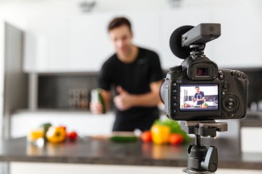 Bir video kamera erkek blogger gülümseyen genç filme yakın çekim