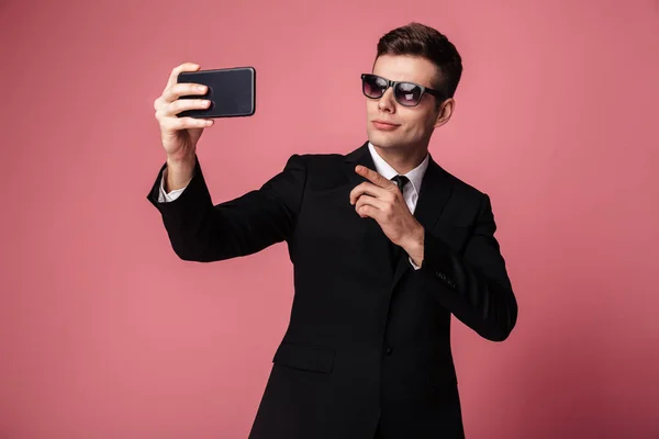 Fiatal üzletember hogy selfie koncentrált, mobil telefon. — Stock Fotó