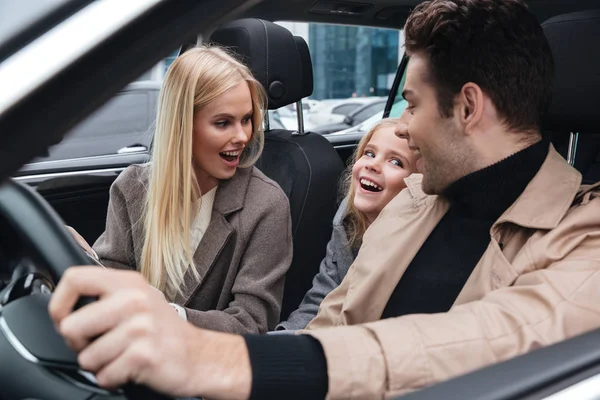 ?homem heerful que senta-se no carro com sua esposa e filha — Fotografia de Stock