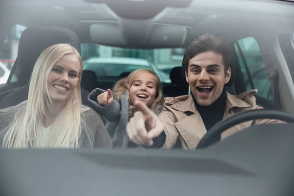 Веселый мужчина, сидящий в машине с женой и дочерью — стоковое фото