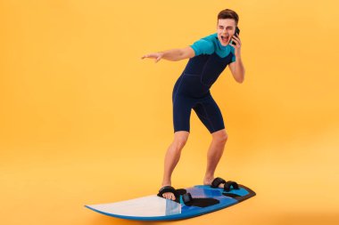 Gülen surfer sörf tahtası kullanarak dalış elbisesi içinde görüntü
