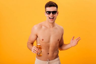 Neşeli çıplak adam şort ve bira tutan güneş gözlüğü
